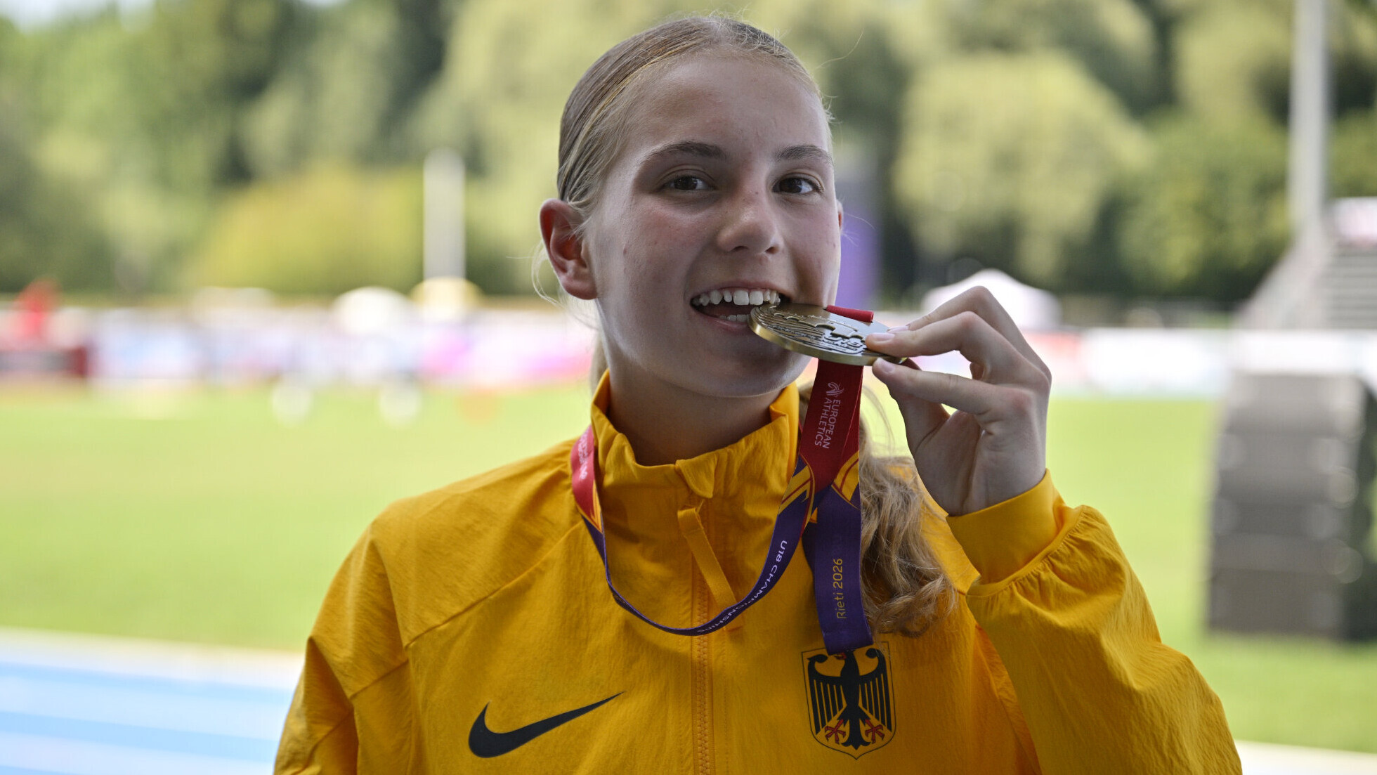 Die deutsche Läuferin Franziska Gräter beißt nach einer Siegerehrung in ihre Goldmedaille.