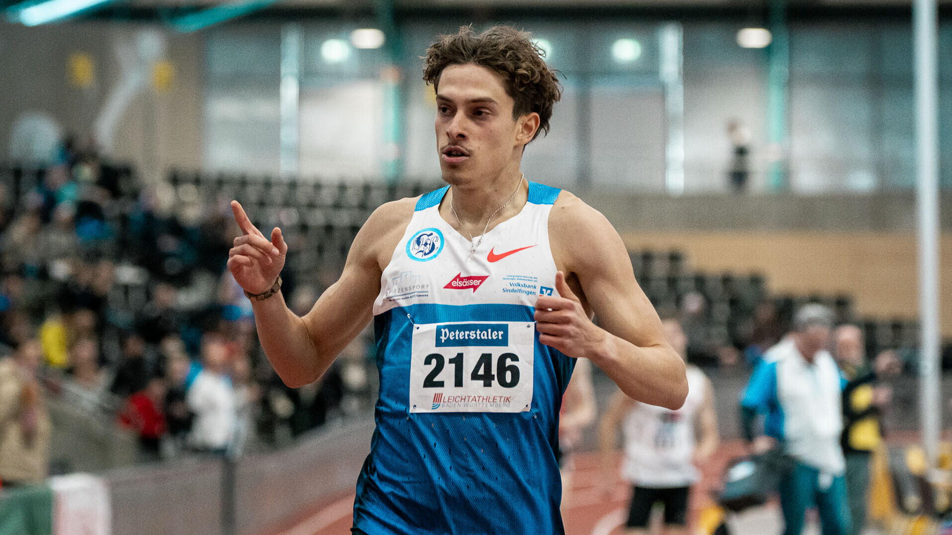 Alexander Stepanov trägt ein Trikot mit der Startnummer 2146 und reckt den rechten Zeigefinger in die Höhe