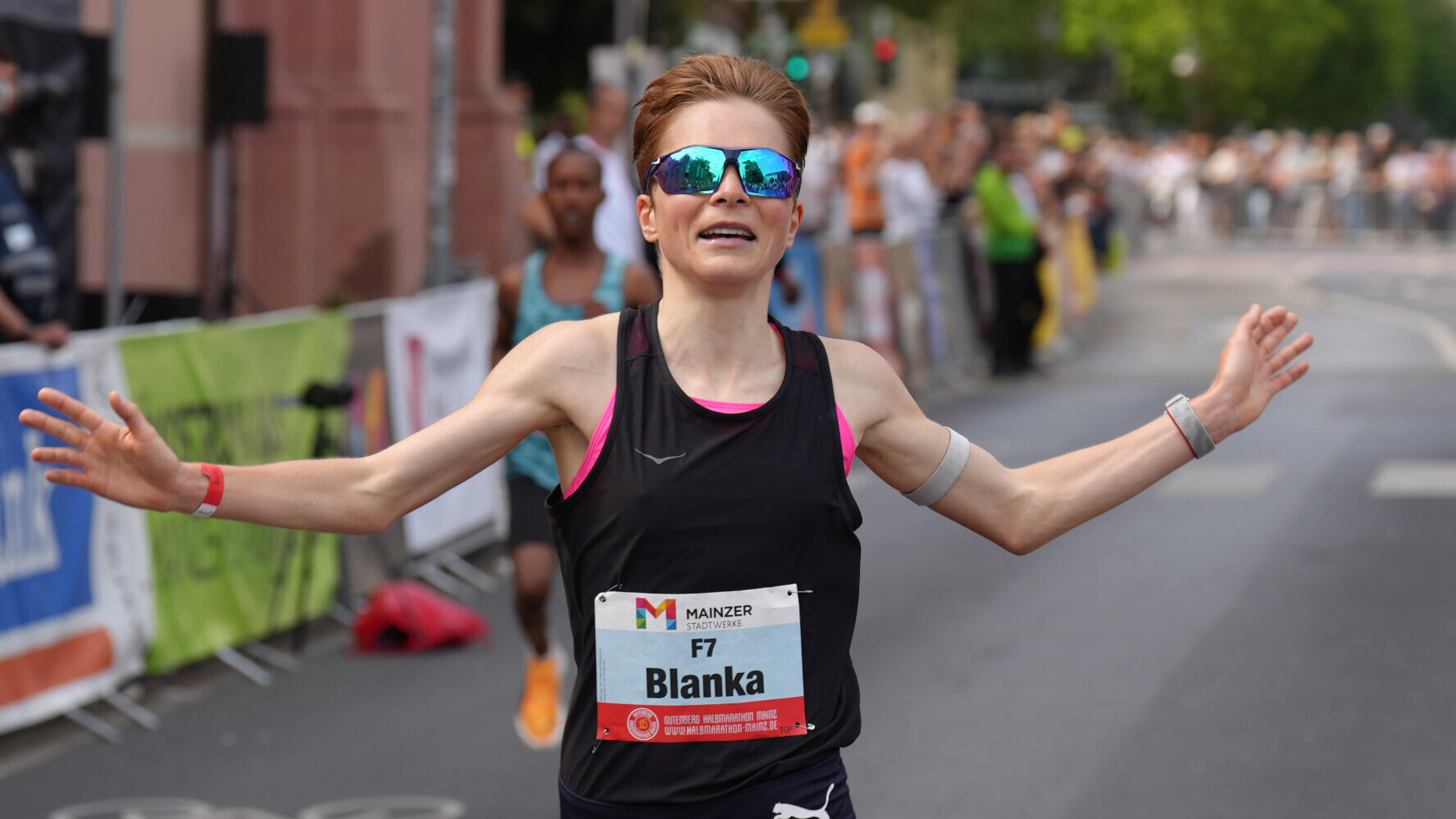 Die deutsche Langstrecklerin Blanka Dörfel hebt bei einem Straßenlauf zum Jubeln seitlich in die Höhe.