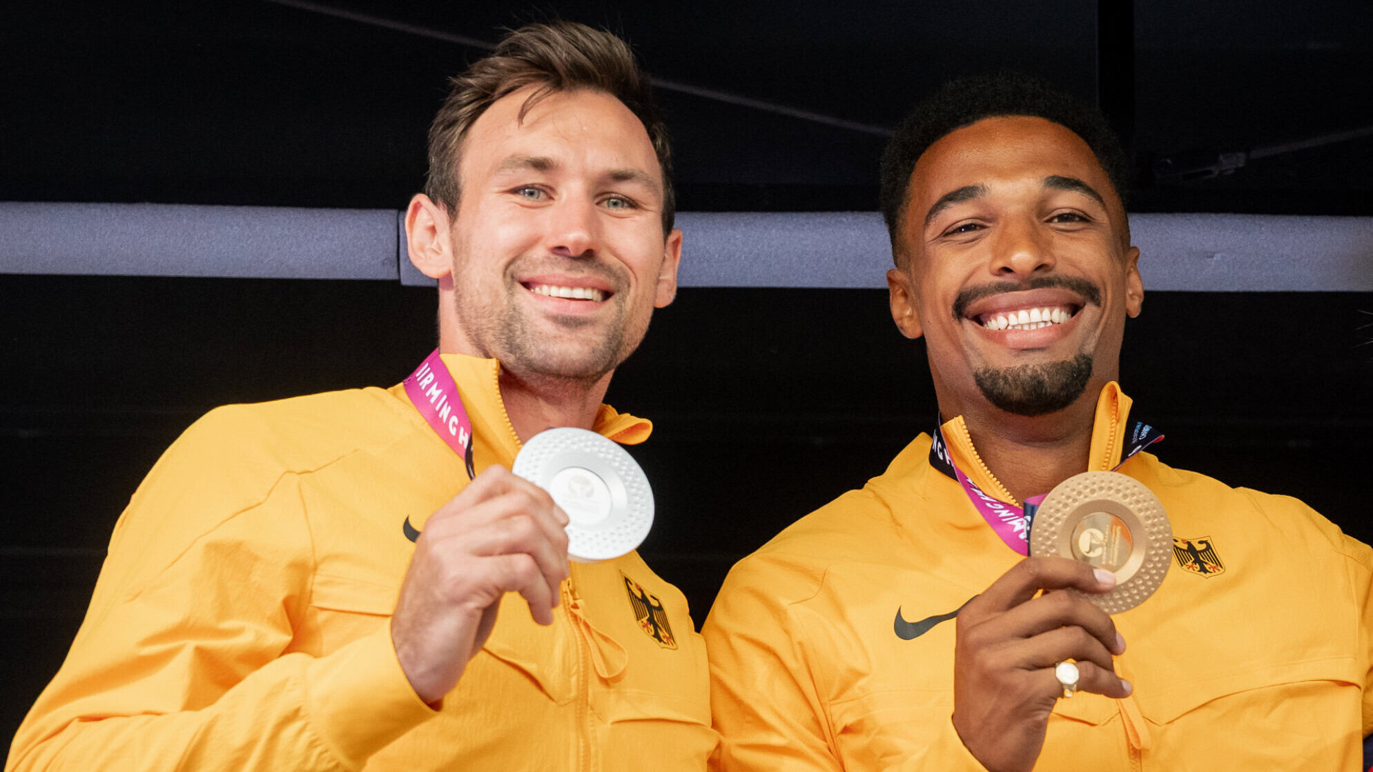 Die deutschen Zehnkämpfer Niklas Kaul lachen in die Kamera lachen und haben ihre Silber- und Goldmedaille in der Hand.
