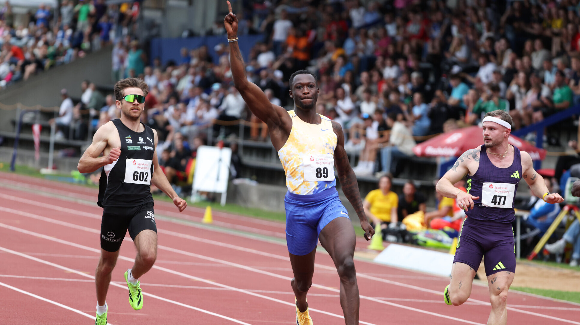 Der deutsche Sprinter Owen Ansah läuft mit nach oben gestrecktem rechten Arm ins Ziel.