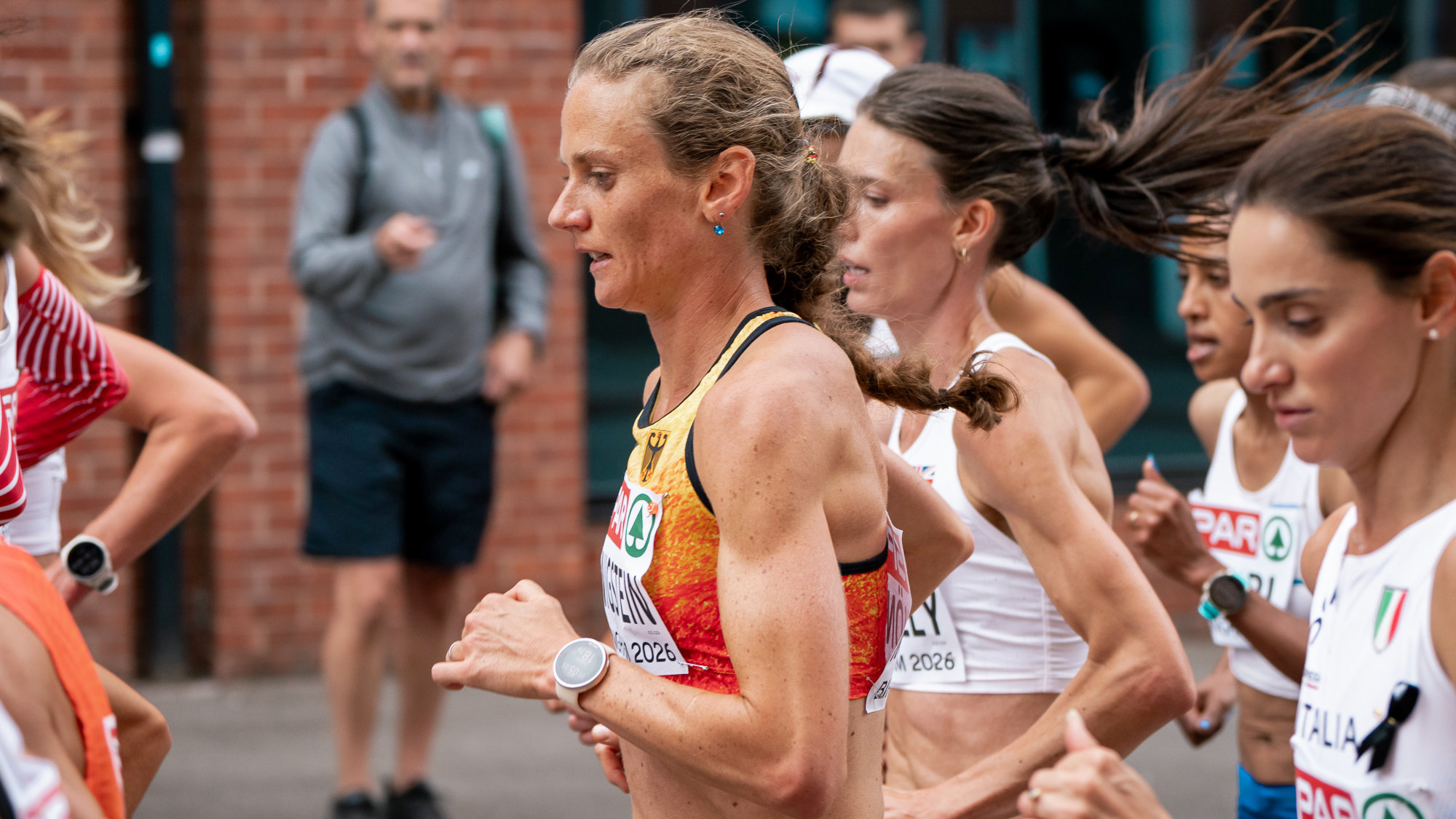 Die deutsche Marathonläuferin Fabienne Königstein läuft im Nationatrikot mitten in einer Gruppe. Das Foto ist seitlich aufgenommen.