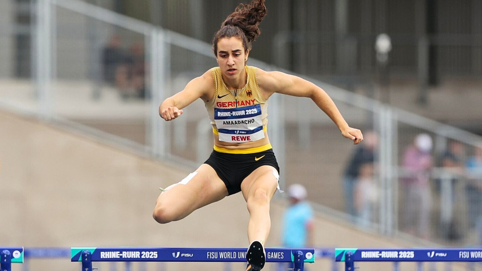 400-Meter-Hürdenläuferin Yasmin Amaadacho überquert eine Hürde mit abgewinkeltem Nachziehbein.