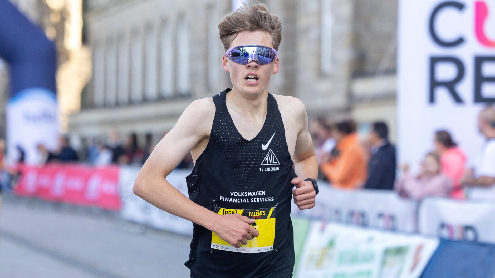Der deutsche Läufer Tom Stephan läuft mit Sonnenbrille bei einem Straßenlauf.