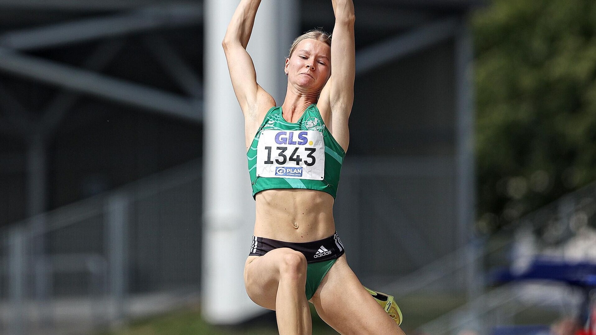Weitspringerin Lynn Michelmann streckt beim Absprung die Arme nach oben.