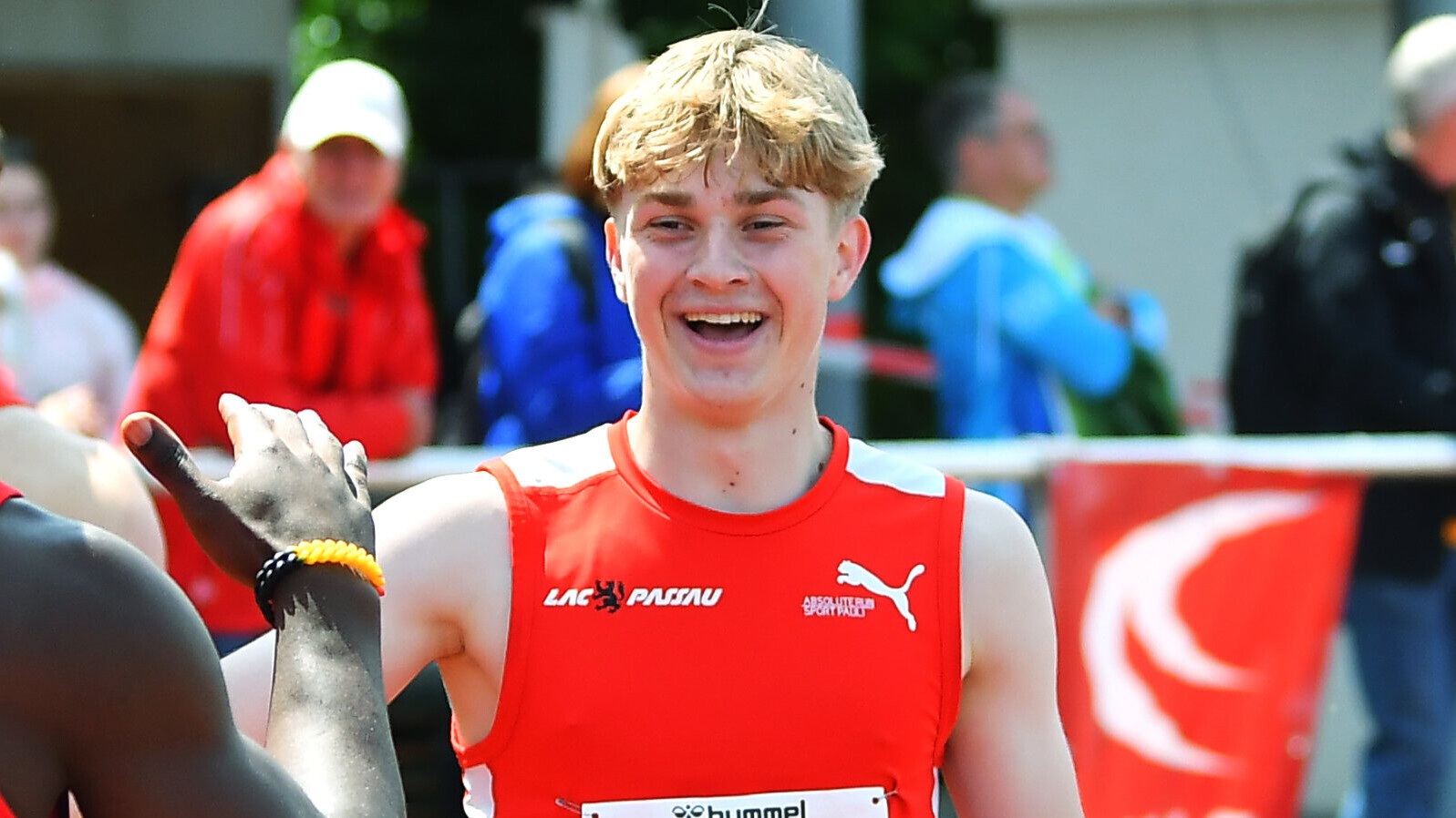 Sprinter Sebastian Hetzner lacht und klatscht einen Konkurrenten ab, von dem man nur den Arm sieht