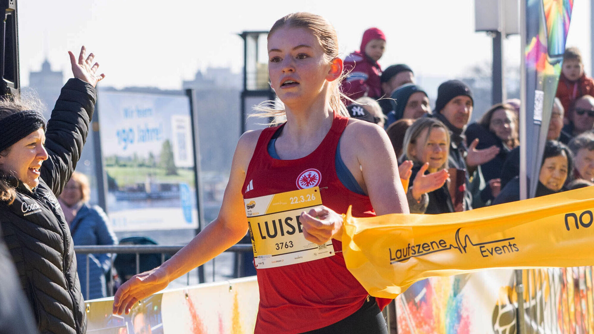 Luise Brzoska erreicht das Zielband, auf dem "Laufszene Events" steht