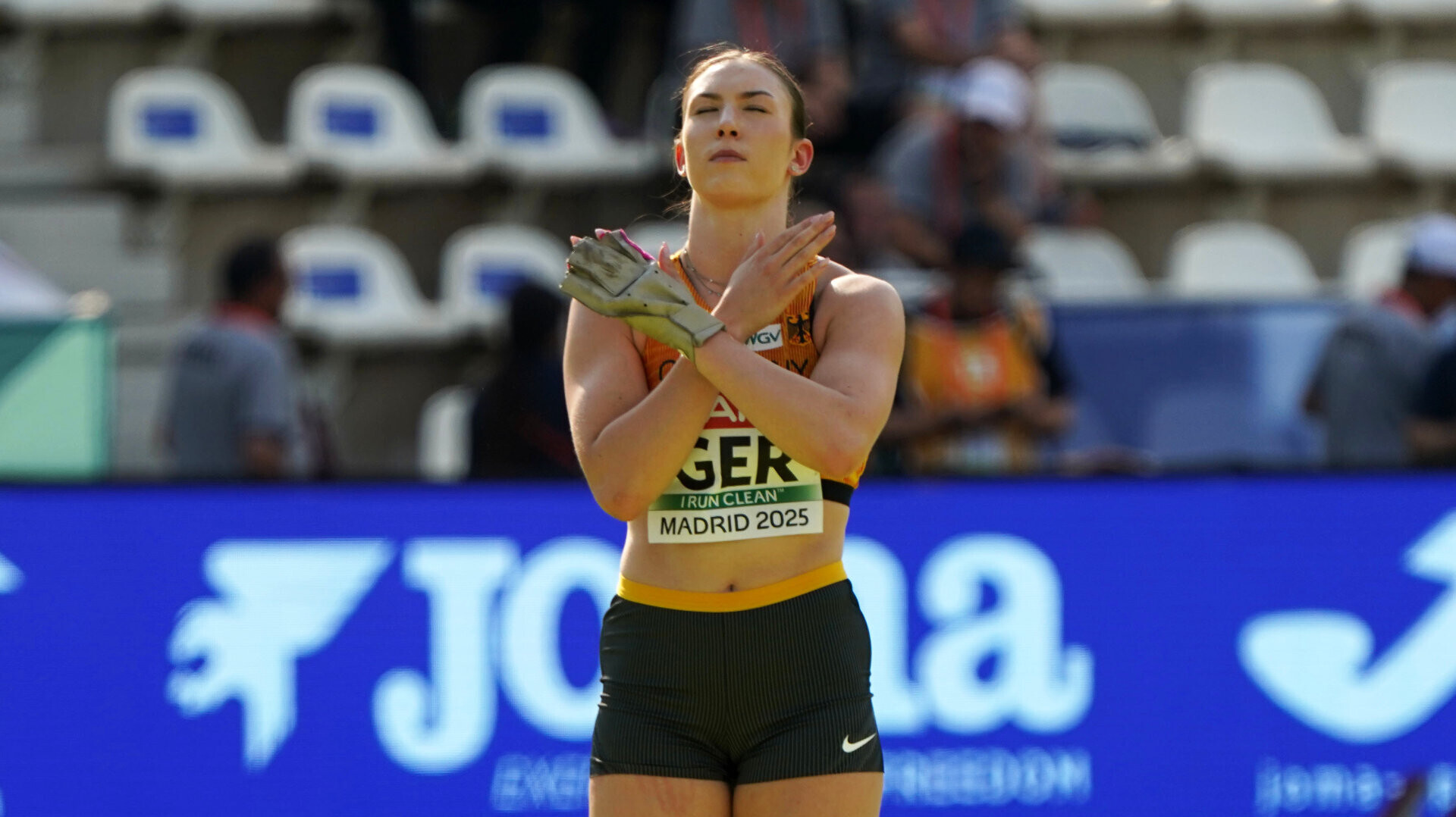 Hammerwerferin Aileen Kuhn im Nationaltrikot, Blick nach oben und Hände vor der Brust verschränkt