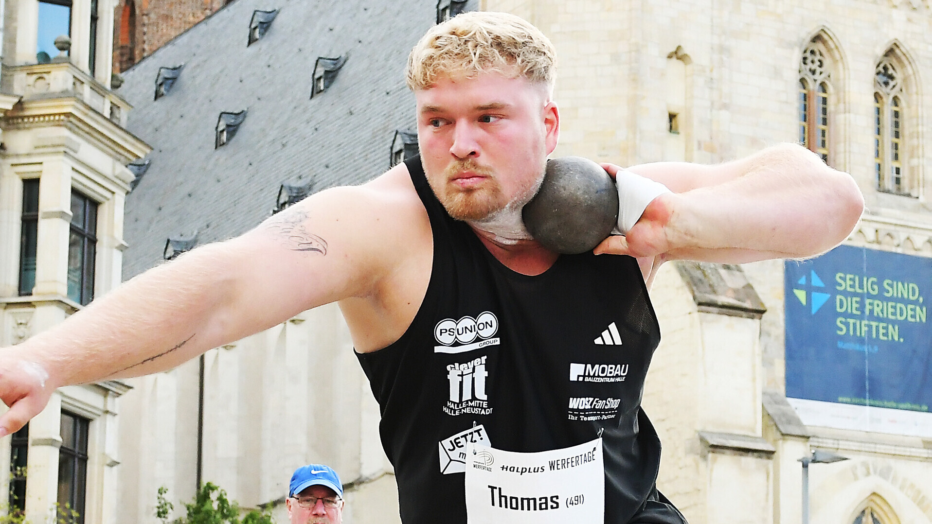 Kugelstoßer Philipp Thomas mit der Kugel am Hals und ausgestrecktem Arm. 