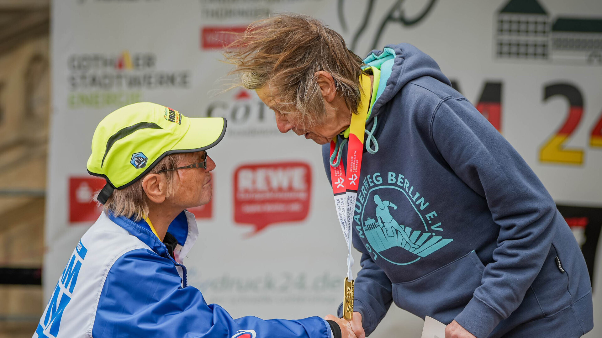 Die Ultraläuferinnen Ursula Dinges und Sigrid Eichner schütteln sich bei der Siegerehrung die Hand