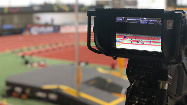 Kamera-Bildschirm gerichtet auf Leichtathletik-Halle mit Rundbahn und Stabhochsprung-Anlage im Hintergrund