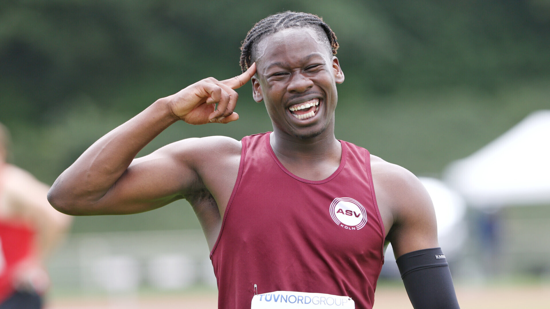 Porträt des lachenden Sprinters Chidiera Onuoha, der salutiert