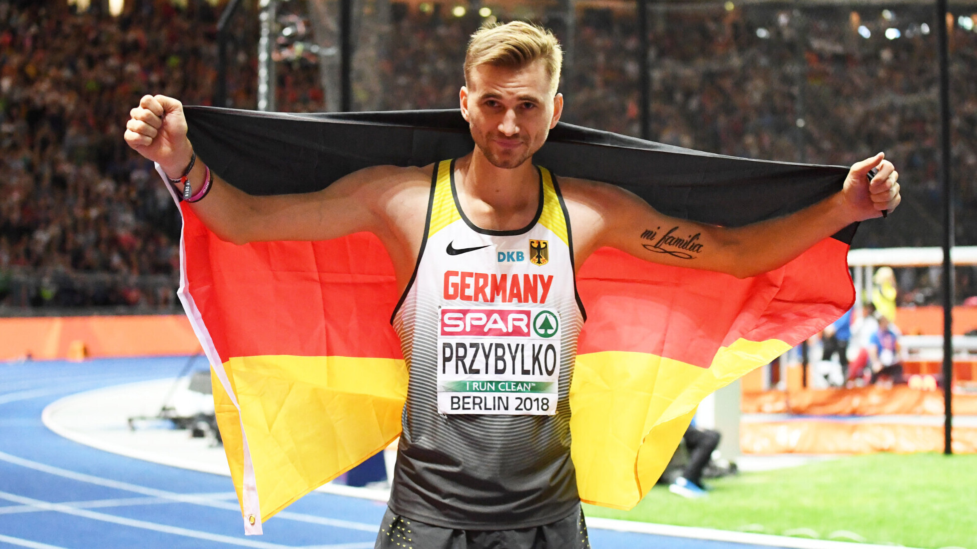 Der deutsche Hochspringer Mateusz Przybylko posiert 2018 bei der EM mit der Deutschlandfahne.