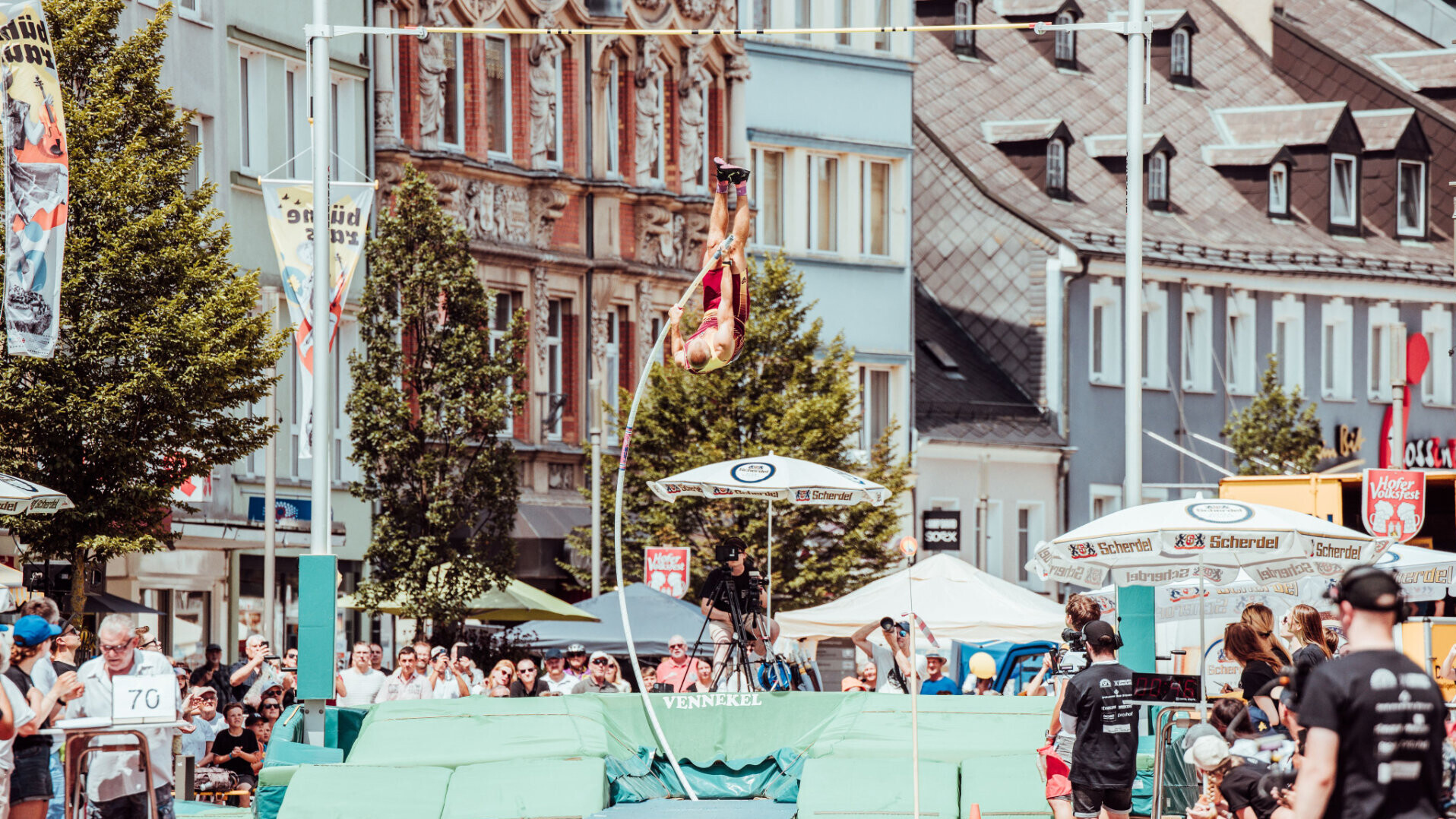 Stabhochsprung-Anlage in der Altstadt von Hof mit Athlet im Sprung und Zuschauern