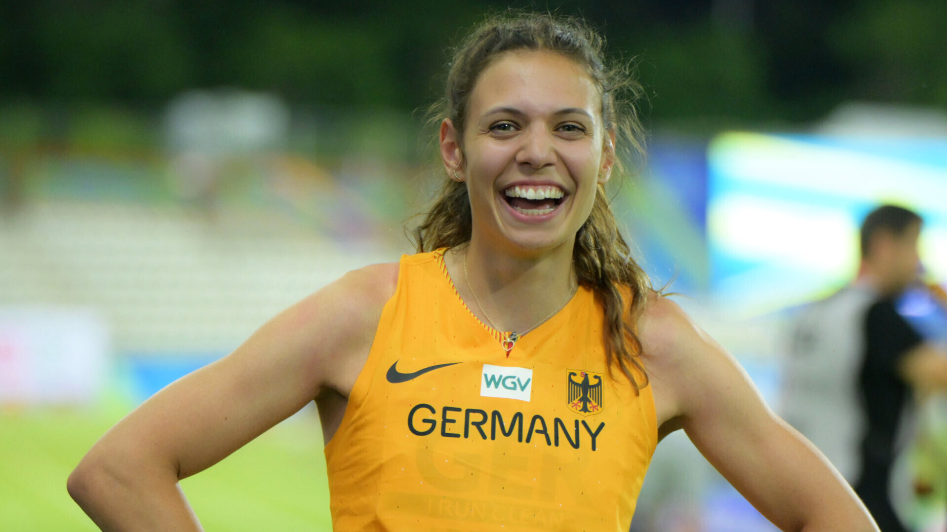 Dreispringerin Caroline Joyeux im Nationaltrikot, lachend mit den Händen in den Hüften