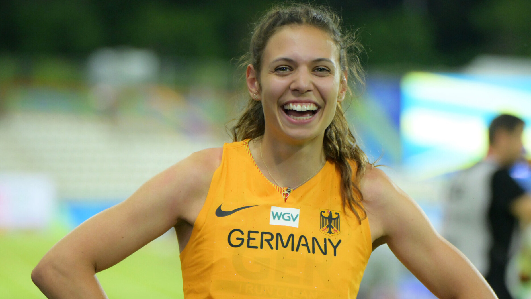 Dreispringerin Caroline Joyeux im Nationaltrikot, lachend mit den Händen in den Hüften