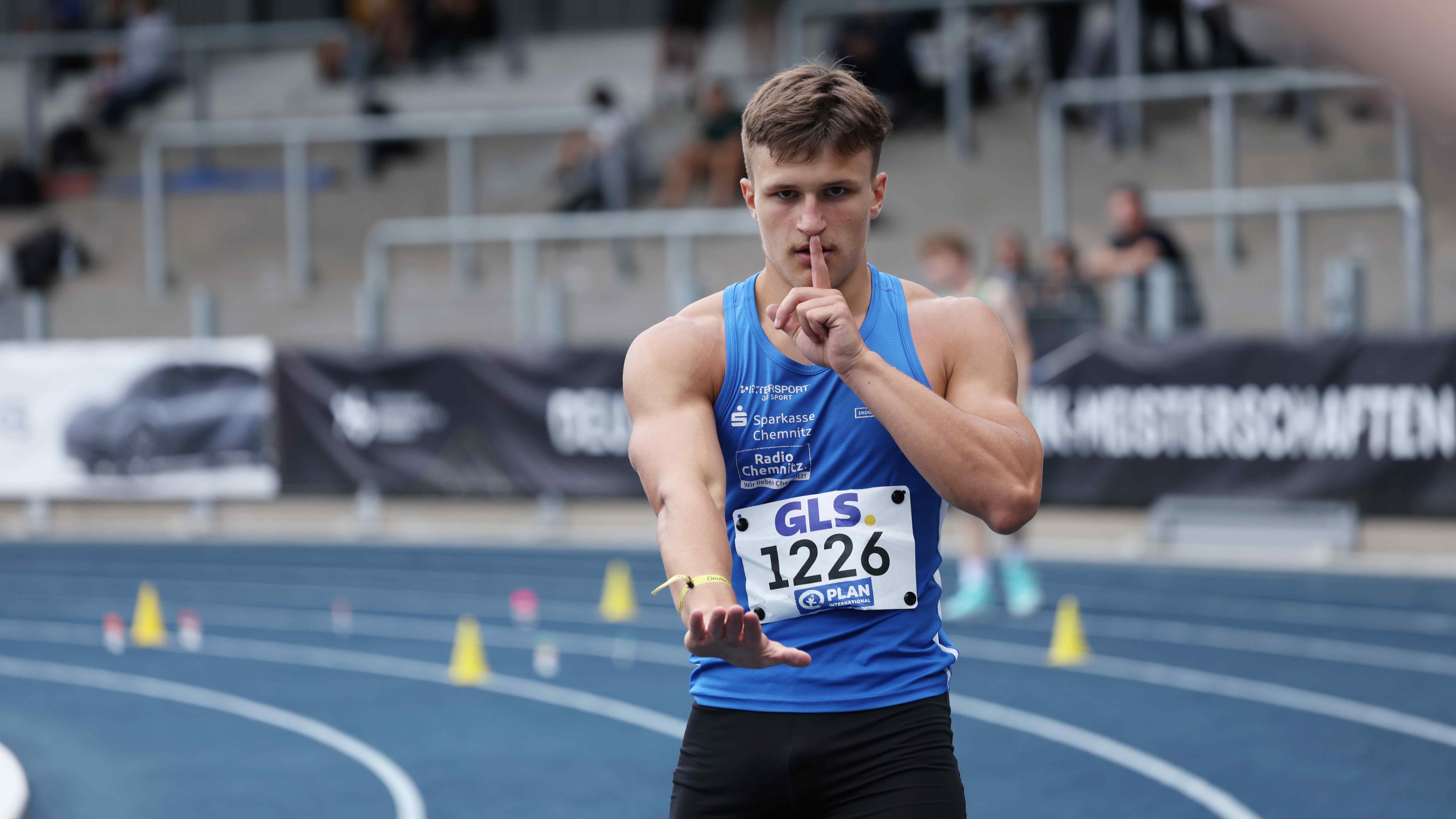 Der deutsche Hürdensprinter Luca Koch hält den Finger an die Lippen