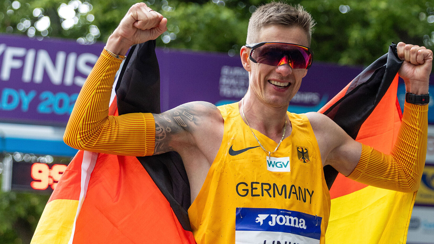 Christopher Linke jubelt mit Deutschlandfahne in der Hand bei der Team-EM der Geher