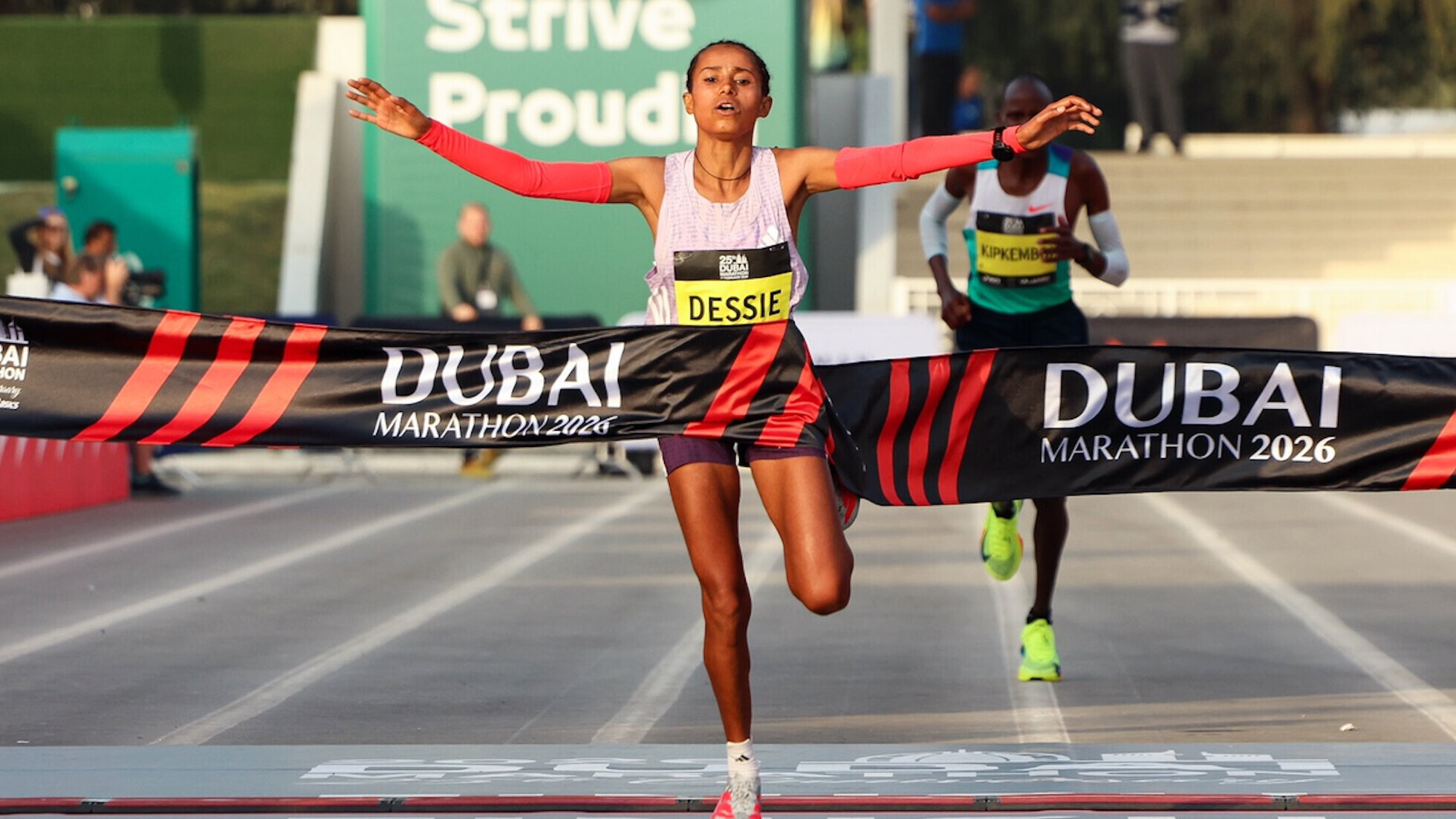 Die äthiopische Marathonläuferin Anchinalu Dessie läuft mit weit ausgestreckten Armen jubelnd beim Dubai-Marathon ins Ziel.