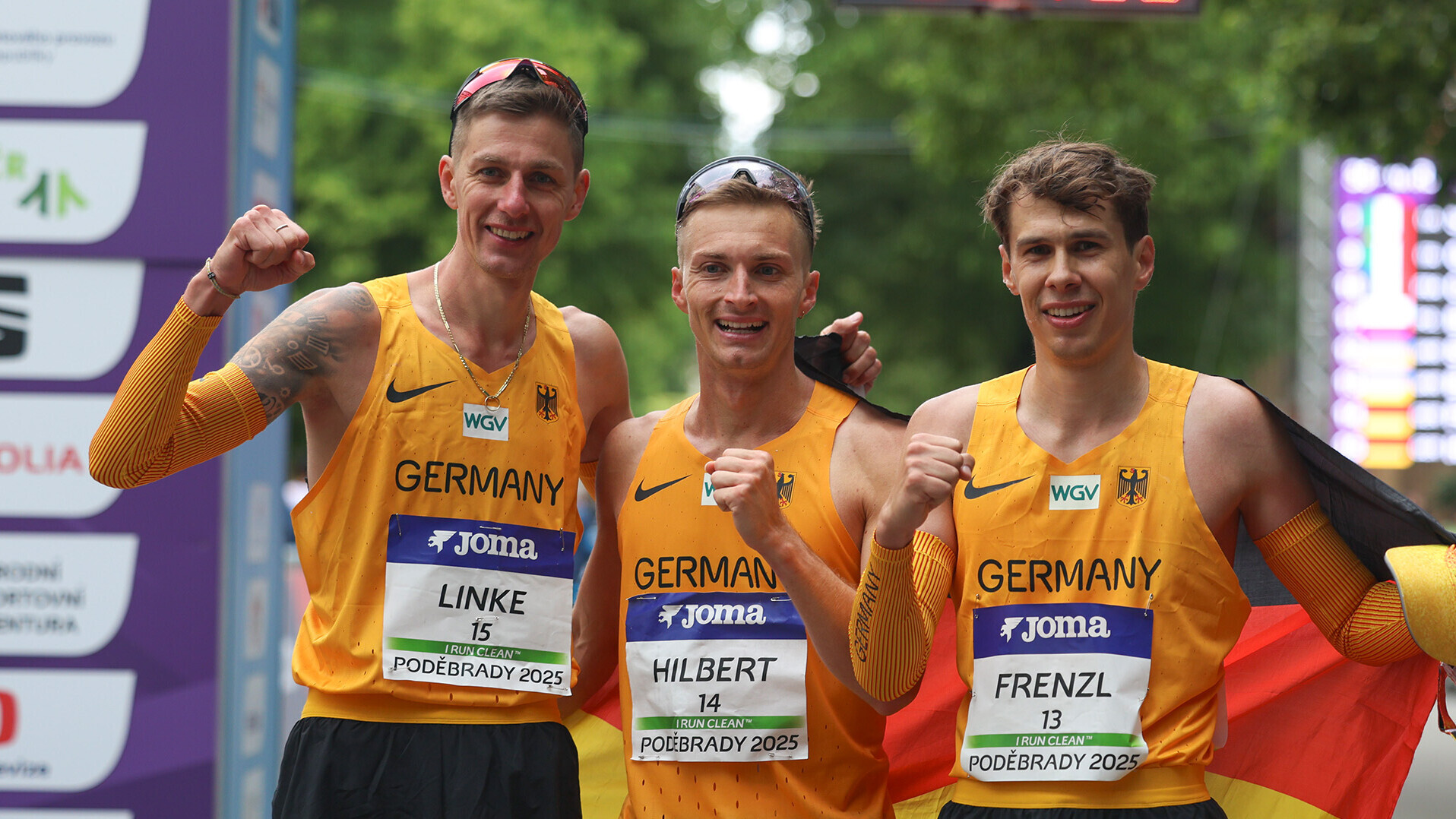 Christopher Linke, Jonathan Hilbert und Johannes Frenzl in Nationaltrikots und mit Deutschlandfahne, Linke mit geballter Faust
