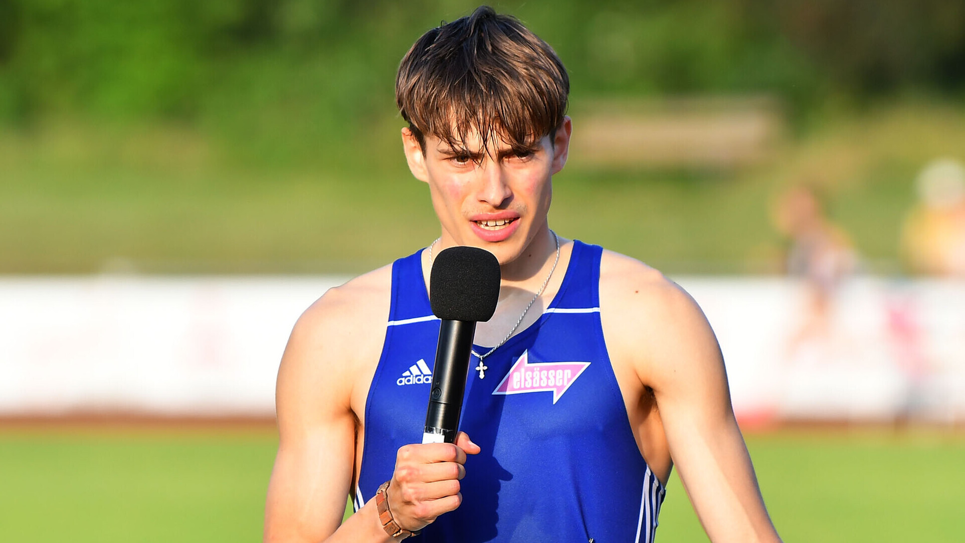 800-Meter-Läufer Alexander Stepanov nach seinem Rennen in Pfungstadt mit einem Mikrofon in der Hand. 