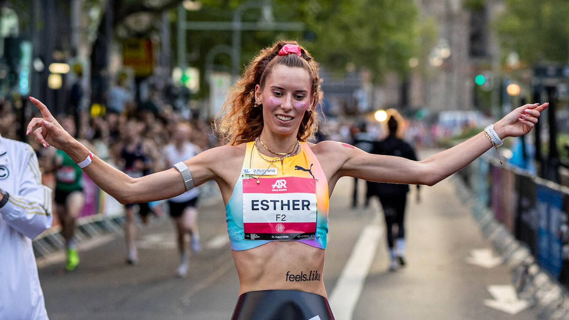 Esther Pfeiffer läuft mit ausgebreiteten Armen auf der Straße