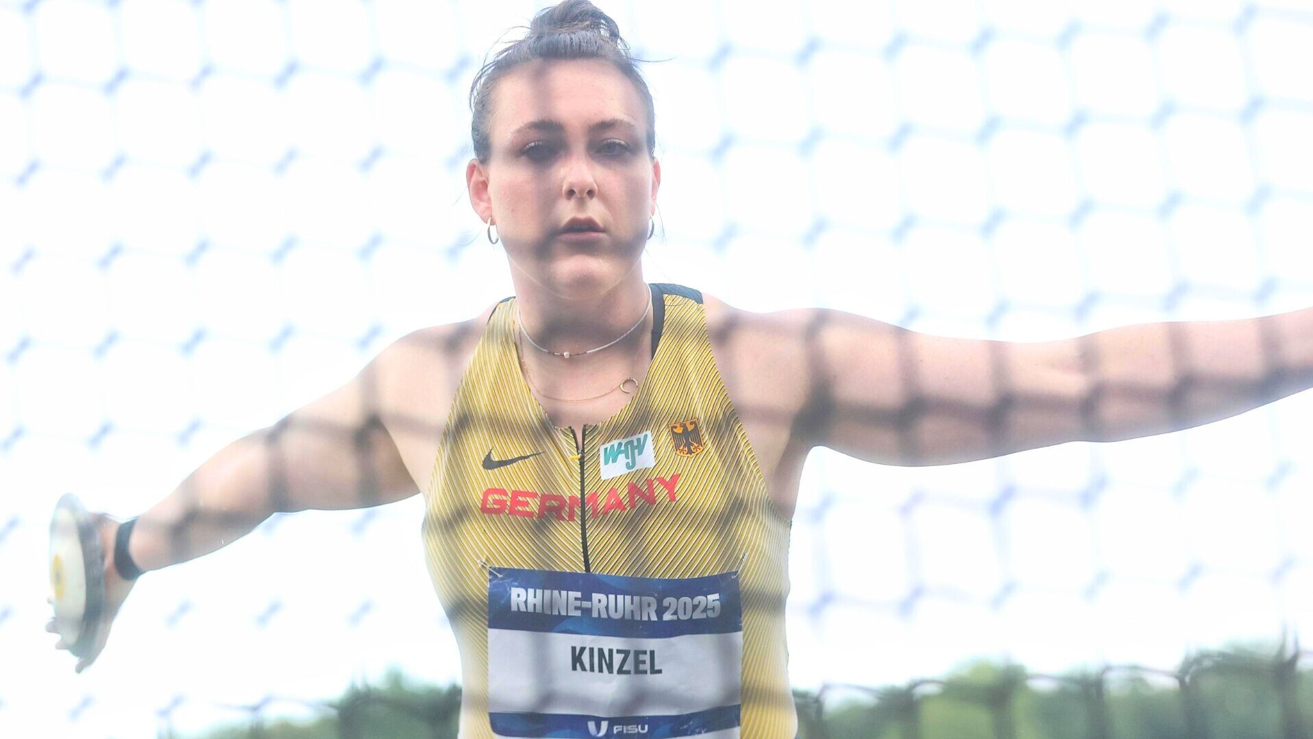 Diskuswerferin Antonia Kinzel mit dem Diskus im Ring hinter dem Netz.