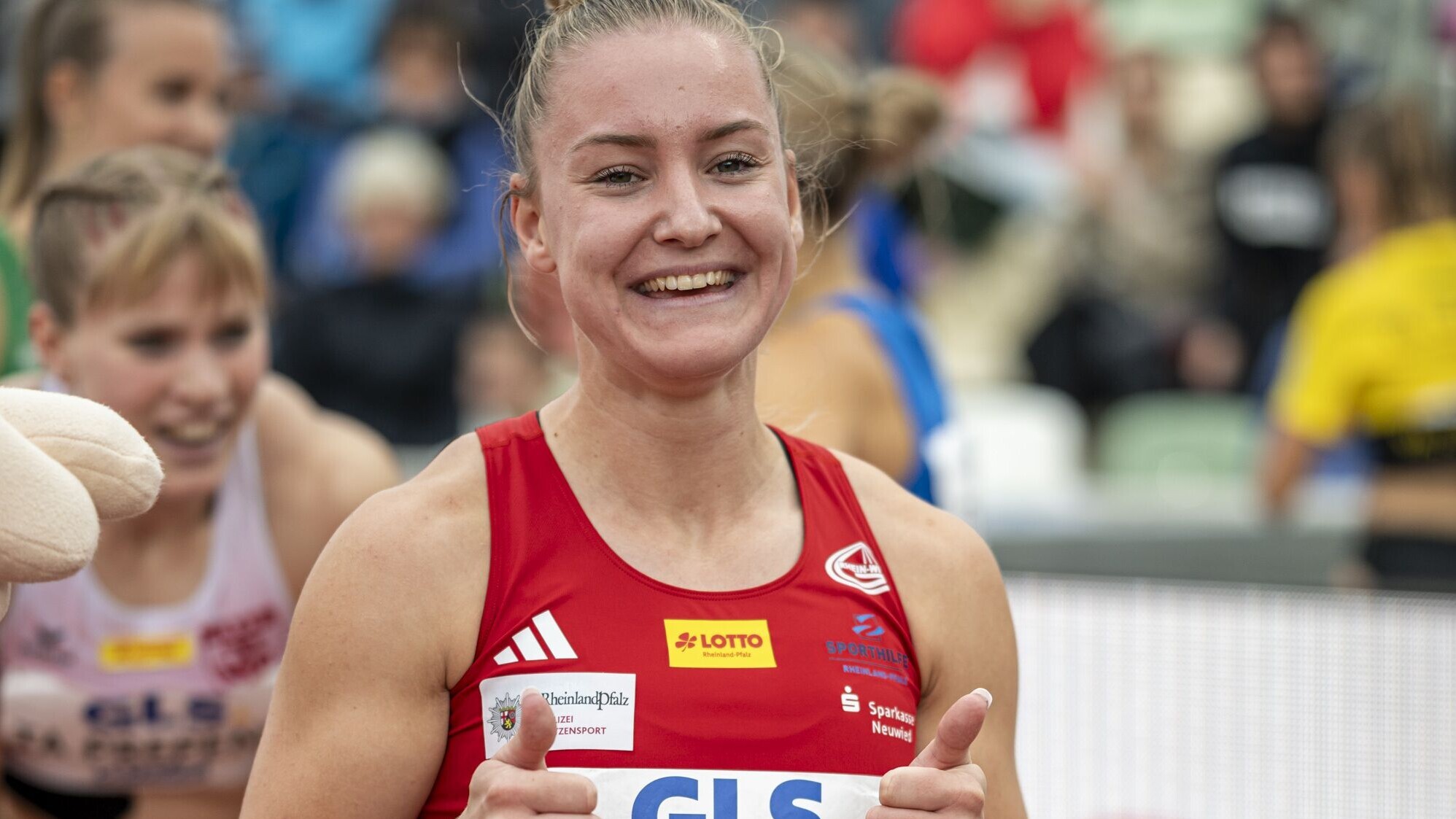 Sophia Junk posiert strahlend mit nach oben gereckten Daumen