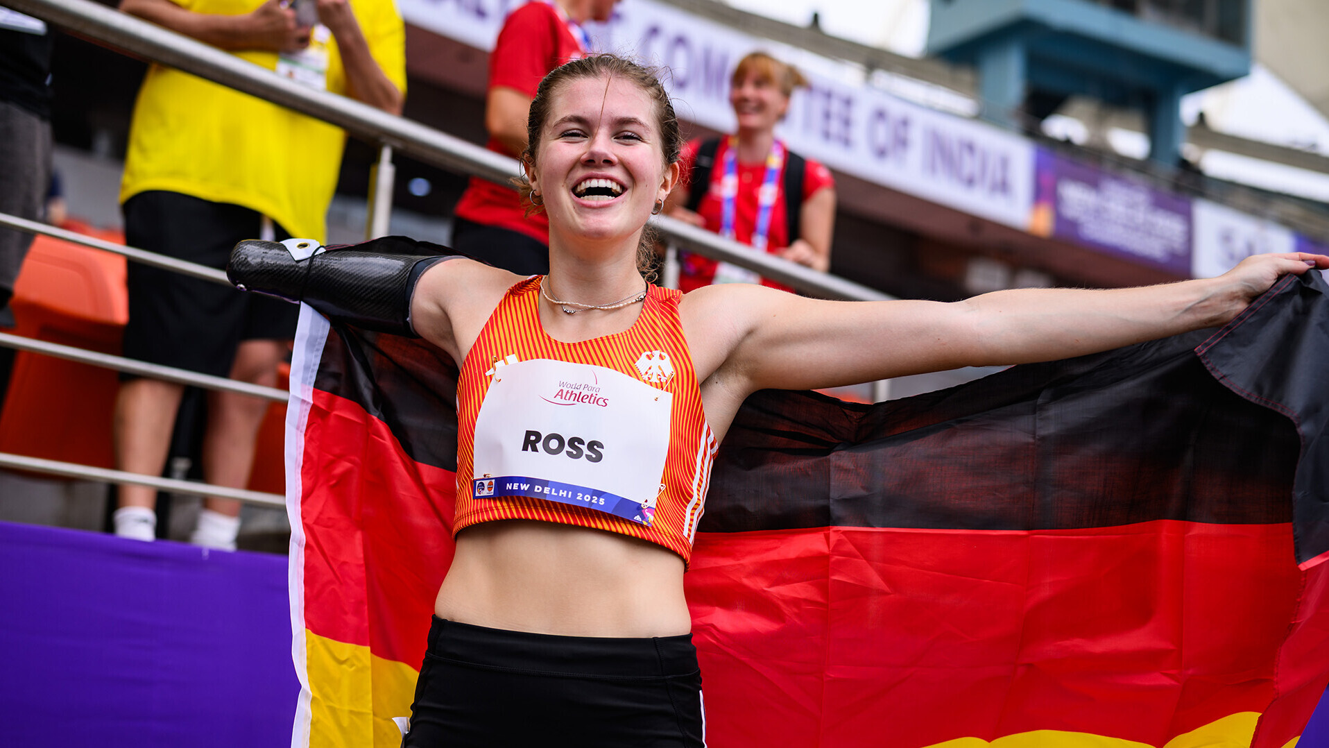 Jule Roß posiert lachend mit Deutschlandfahne