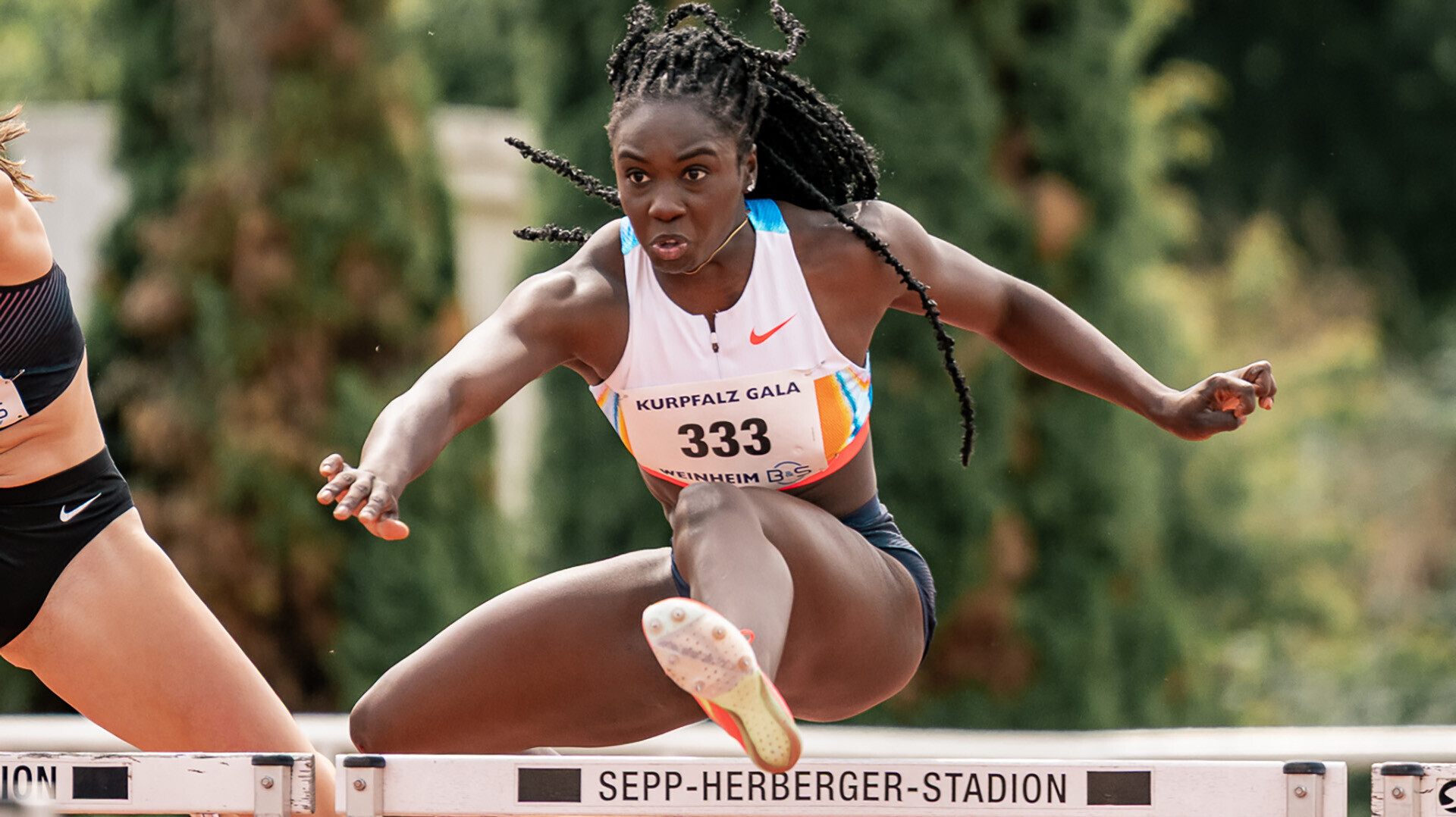 Hawa Jalloh bei der Kurpfalz-Gala Weinheim beim Überqueren einer Hürde, die mit "Sepp-Herberger-Stadion" beschriftet ist. 