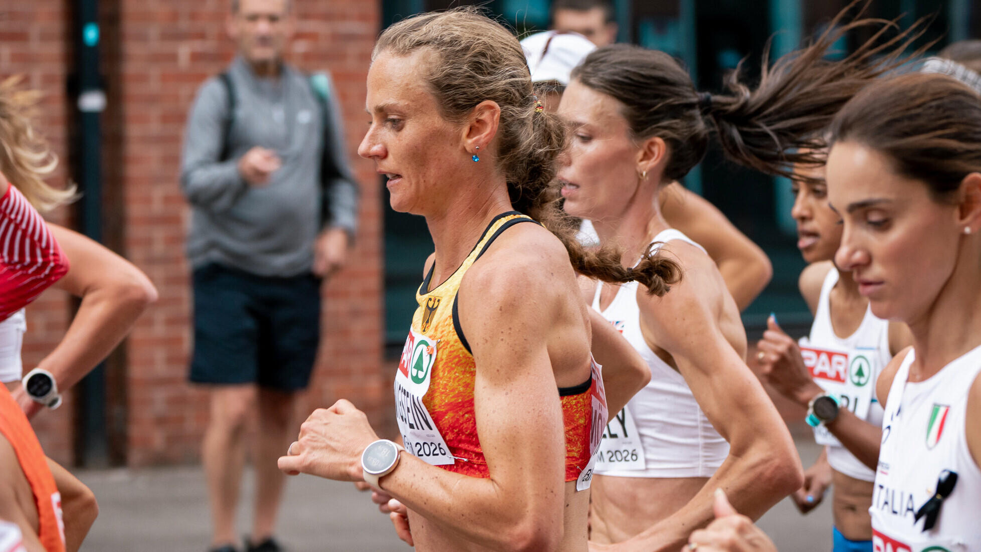 Die deutsche Marathonläuferin Fabienne Königstein läuft im Nationatrikot mitten in einer Gruppe. Das Foto ist seitlich aufgenommen.