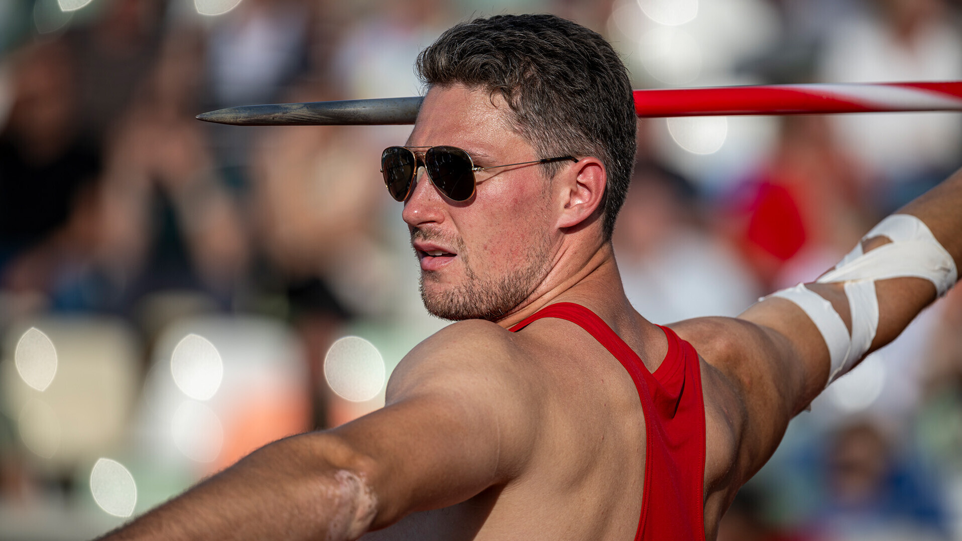 Andreas Bechmann mit Sonnenbrille und dem Speer in der ausgestreckten Hand