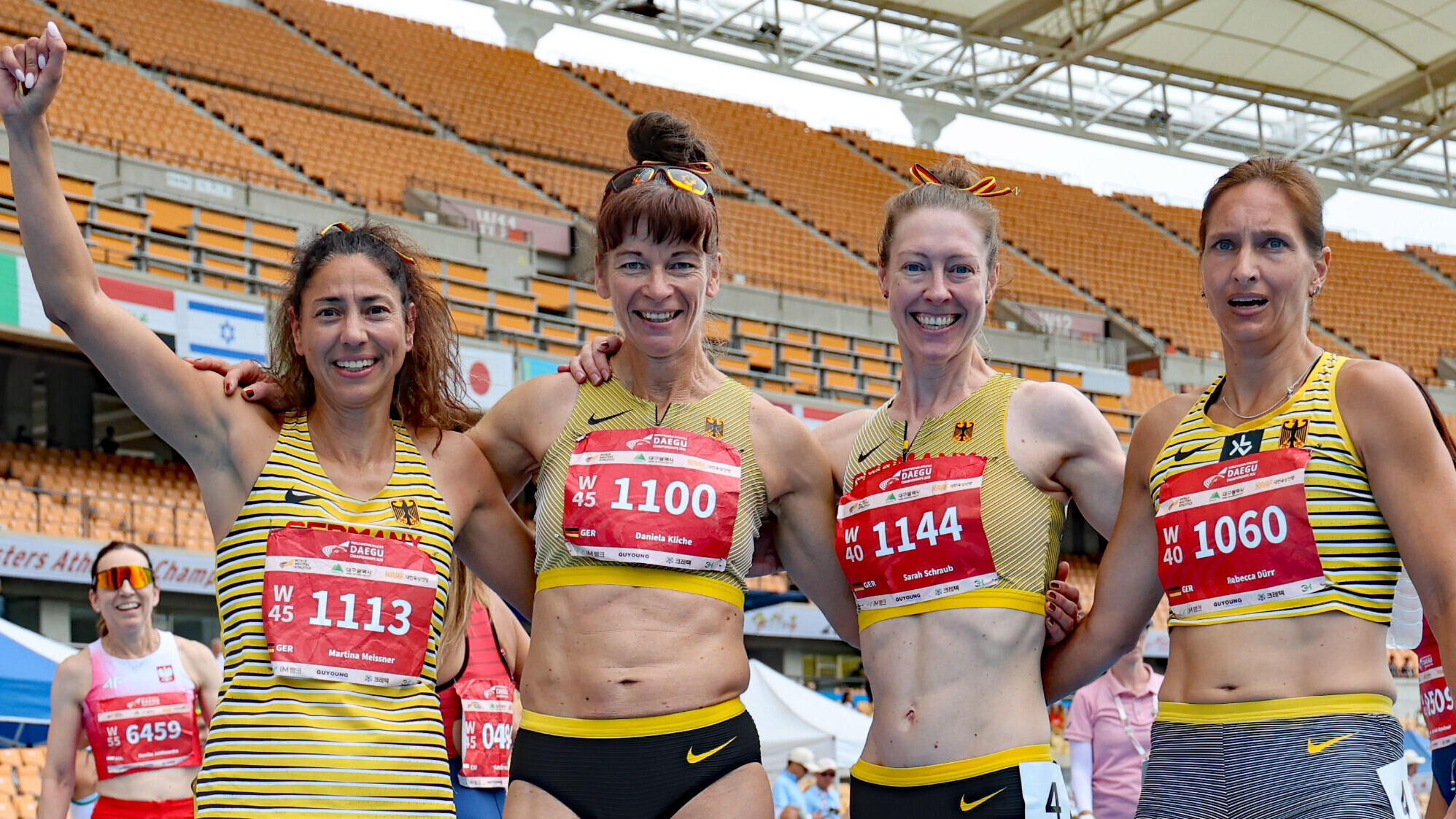Vier Masters-Athletinnen im Deutschlandtrikot lächeln Arm in Arm in die Kamera.