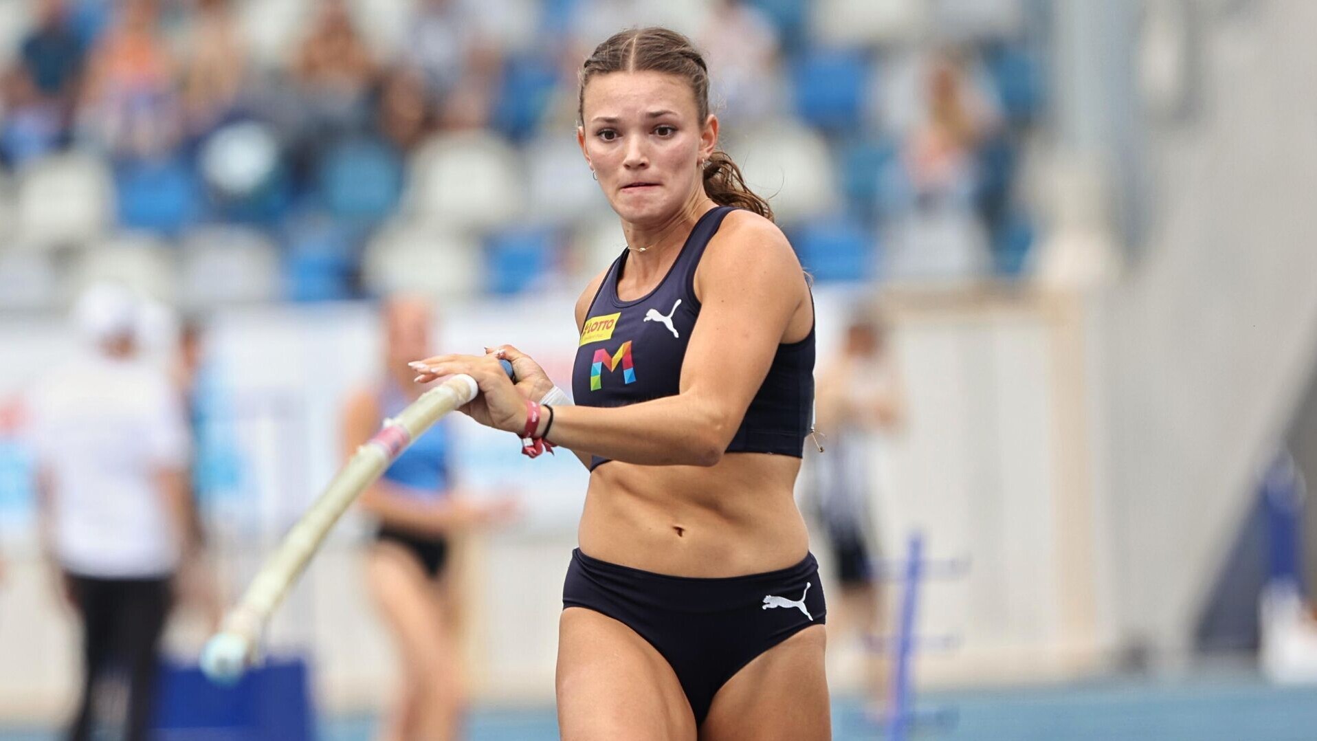Stabhochspringerin Lotte Gretzler beim Anlauf mit dem Stab in der Hand.