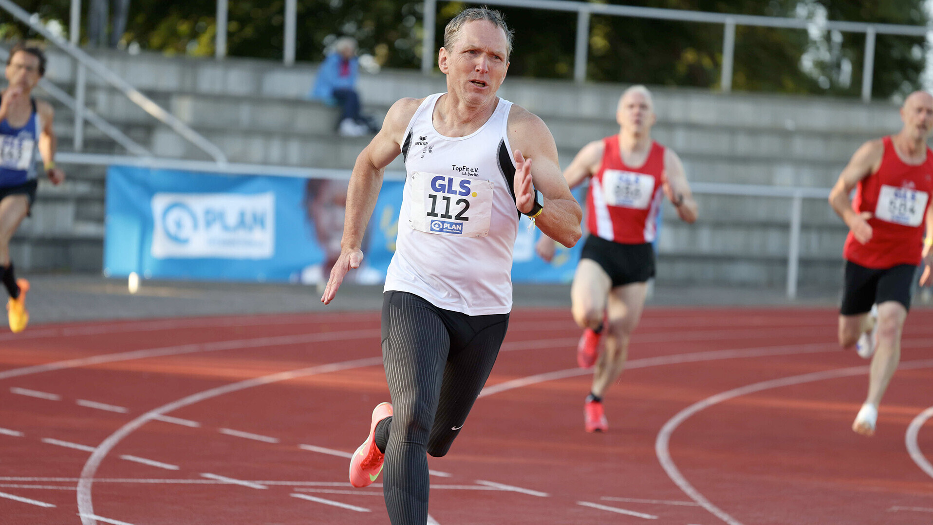 Roland Gröger sprintet im weißen Trikot durch die Kurve