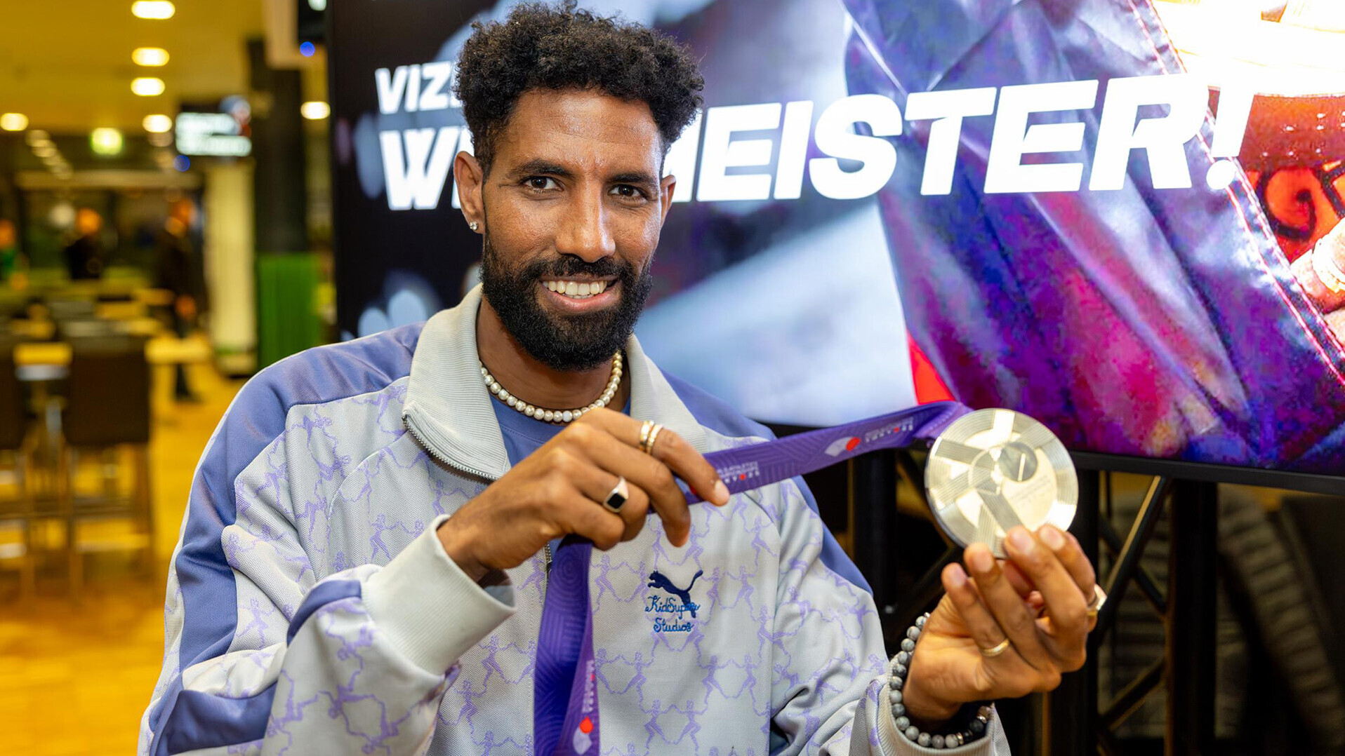 Amanal Petros zeigt seine Silbermedaille vor einem Banner mit der Aufschrift "Vize-Weltmeister"