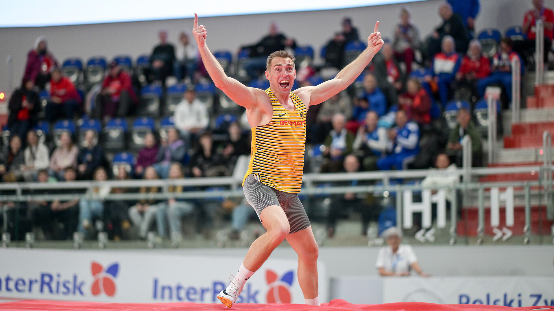 Thomas Ritte steht mit hochgerissenen Armen auf der Stabhochsprungmatte