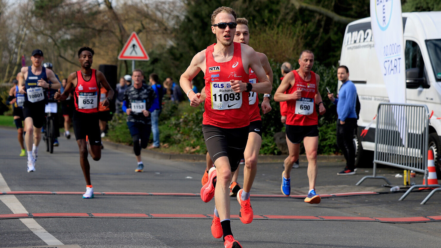 Richard Ringer läuft mit Sonnenbrille bei einem Straßenlauf vorneweg. 