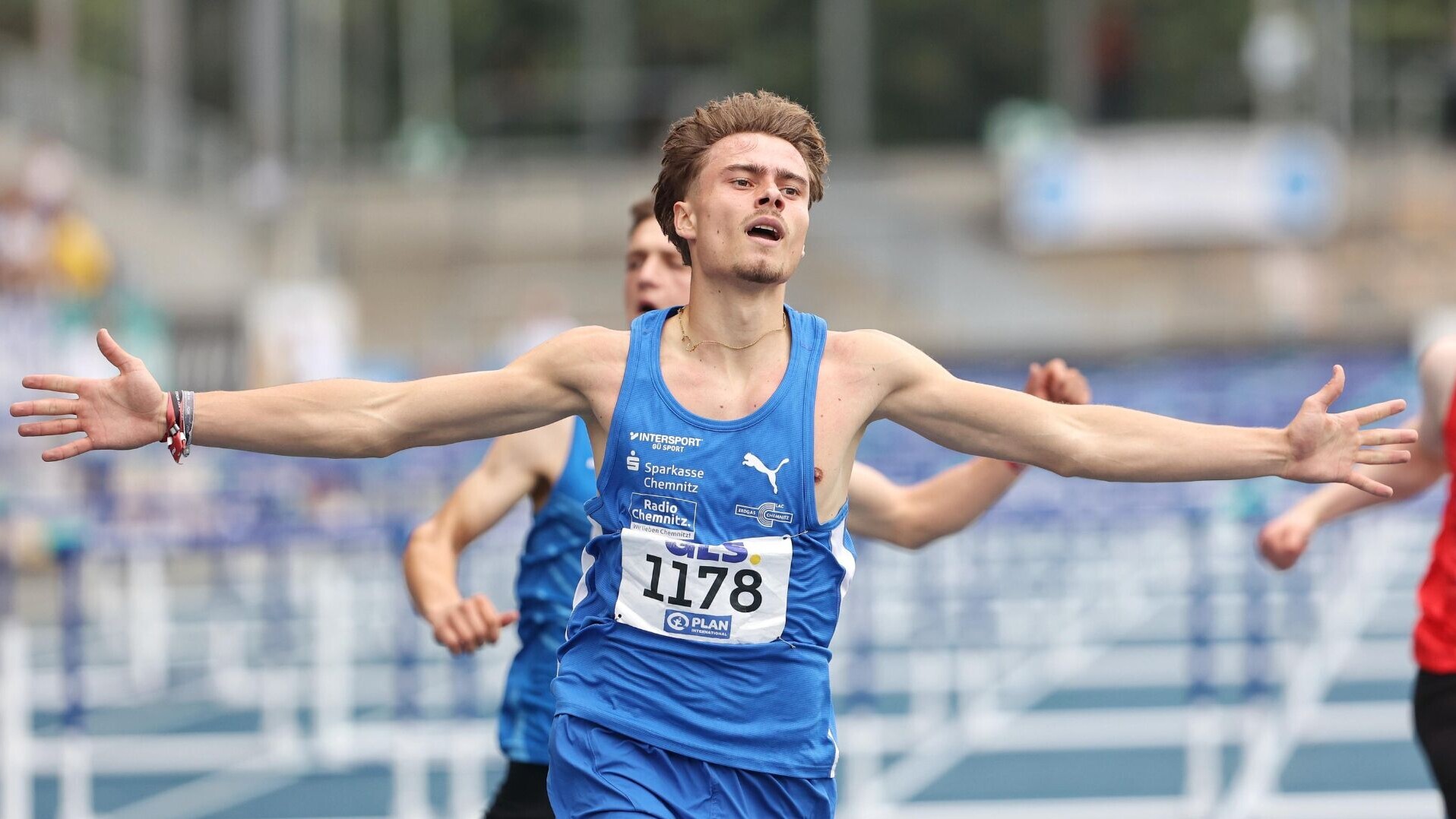 Hürdensprinter Arne Döring läuft mit ausgebreiteten Armen ins Ziel.