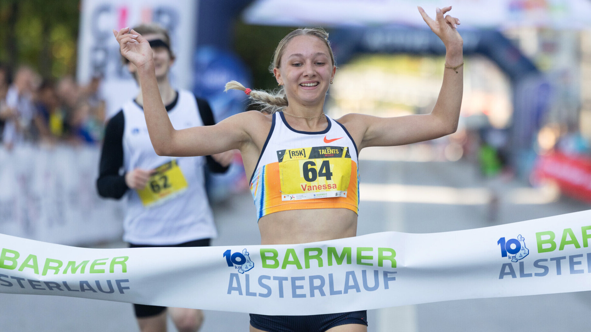 Die deutsche Langstrecklerin Vanessa Mikitenko durchläuft jubelnd ein Zielband und streckt dabei die Arme zur Jubelpose in die Höhe.