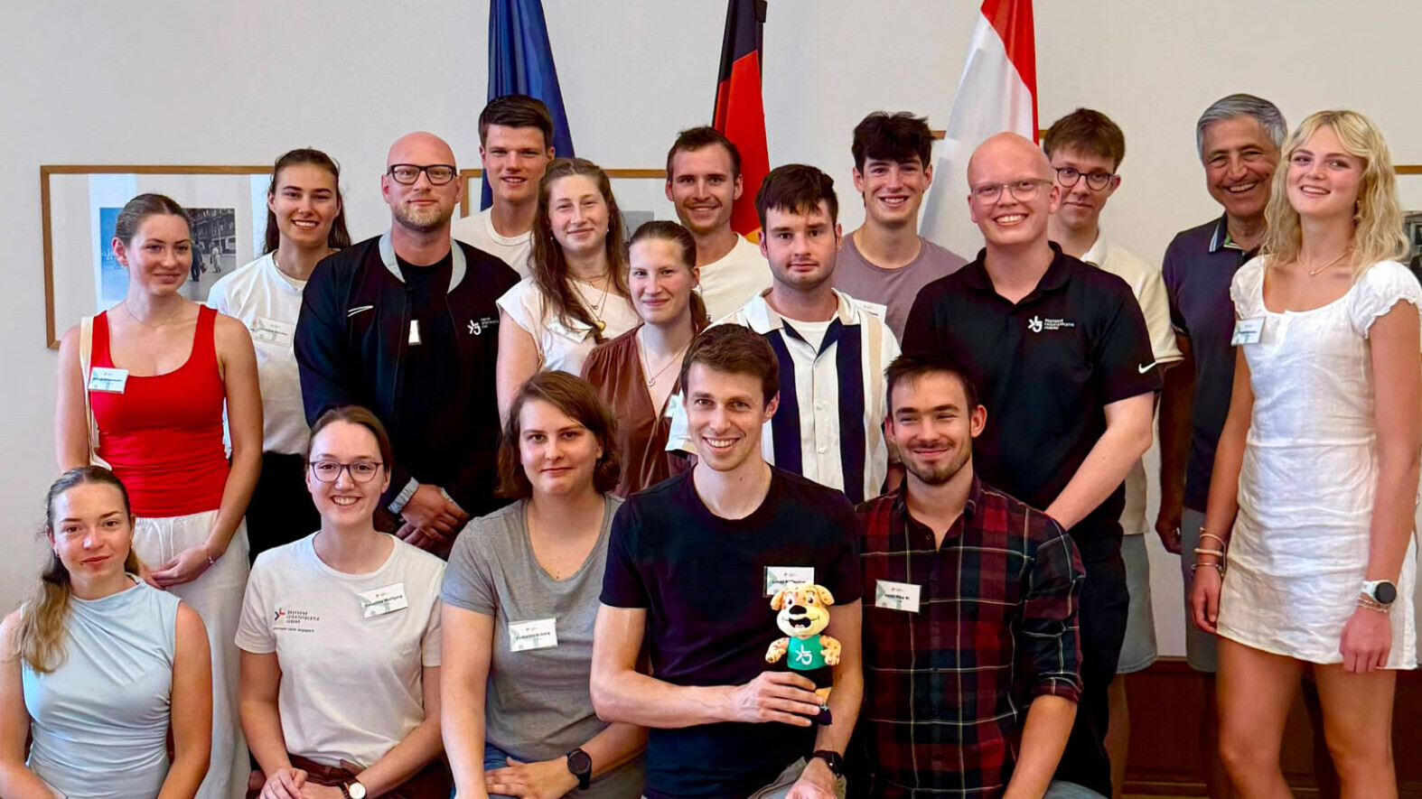 Ein Gruppenbild mit etwa 15 jungen Personen in einem Gebäude.