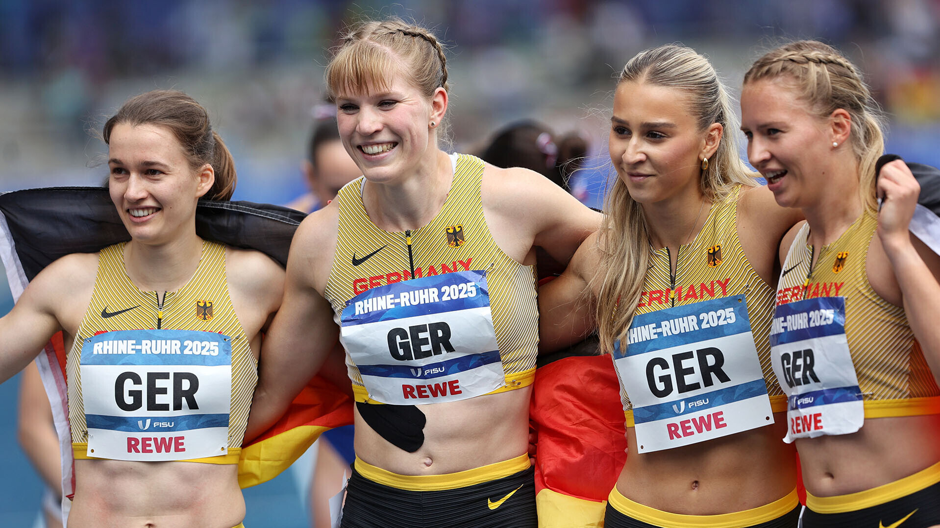 Louise Wieland, Talea Prepens, Jolina Ernst und Svenja Pfetsch in eine Deutschlandfahne gehüllt