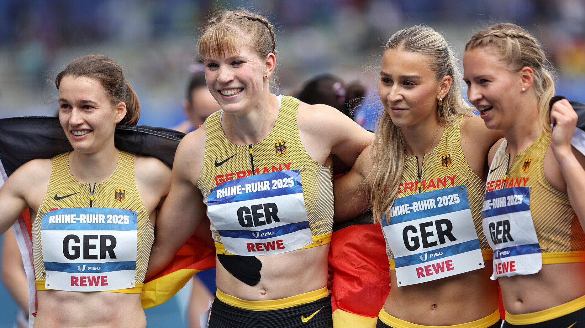 Louise Wieland, Talea Prepens, Jolina Ernst und Svenja Pfetsch in eine Deutschlandfahne gehüllt