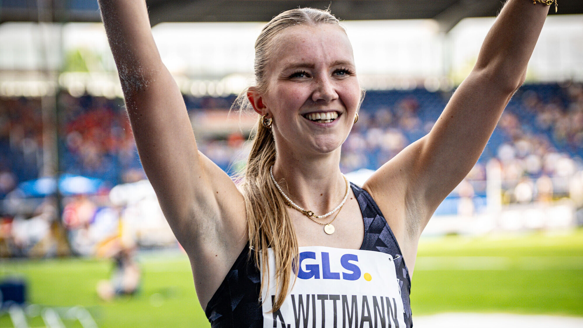 Kira Wittmann reckt lächelnd die Arme in die Höhe