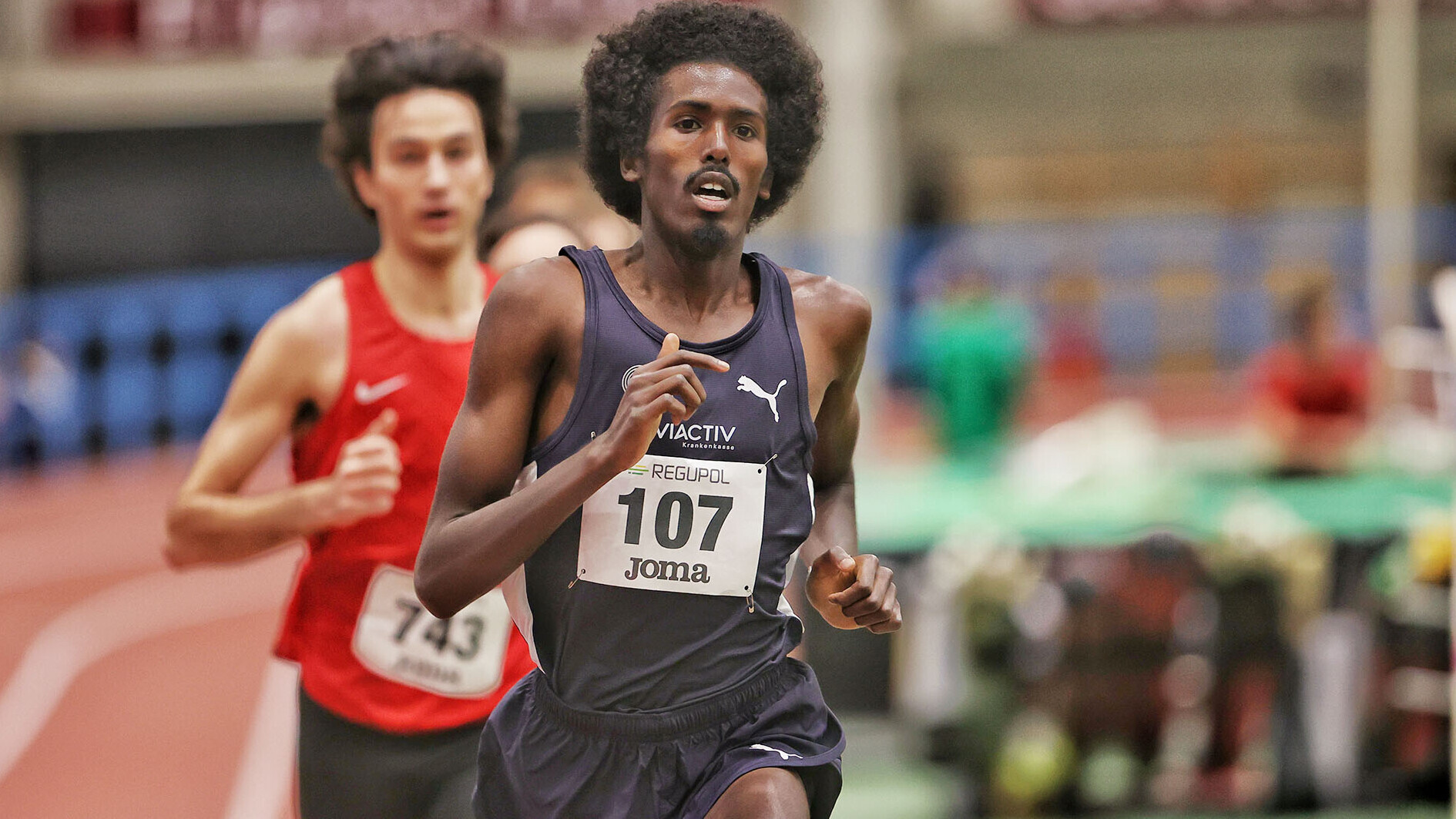 Läufer Mohamed Abdilaahi im schwarzen Trikot während eines Rennens bei einem Hallen-Wettkampf