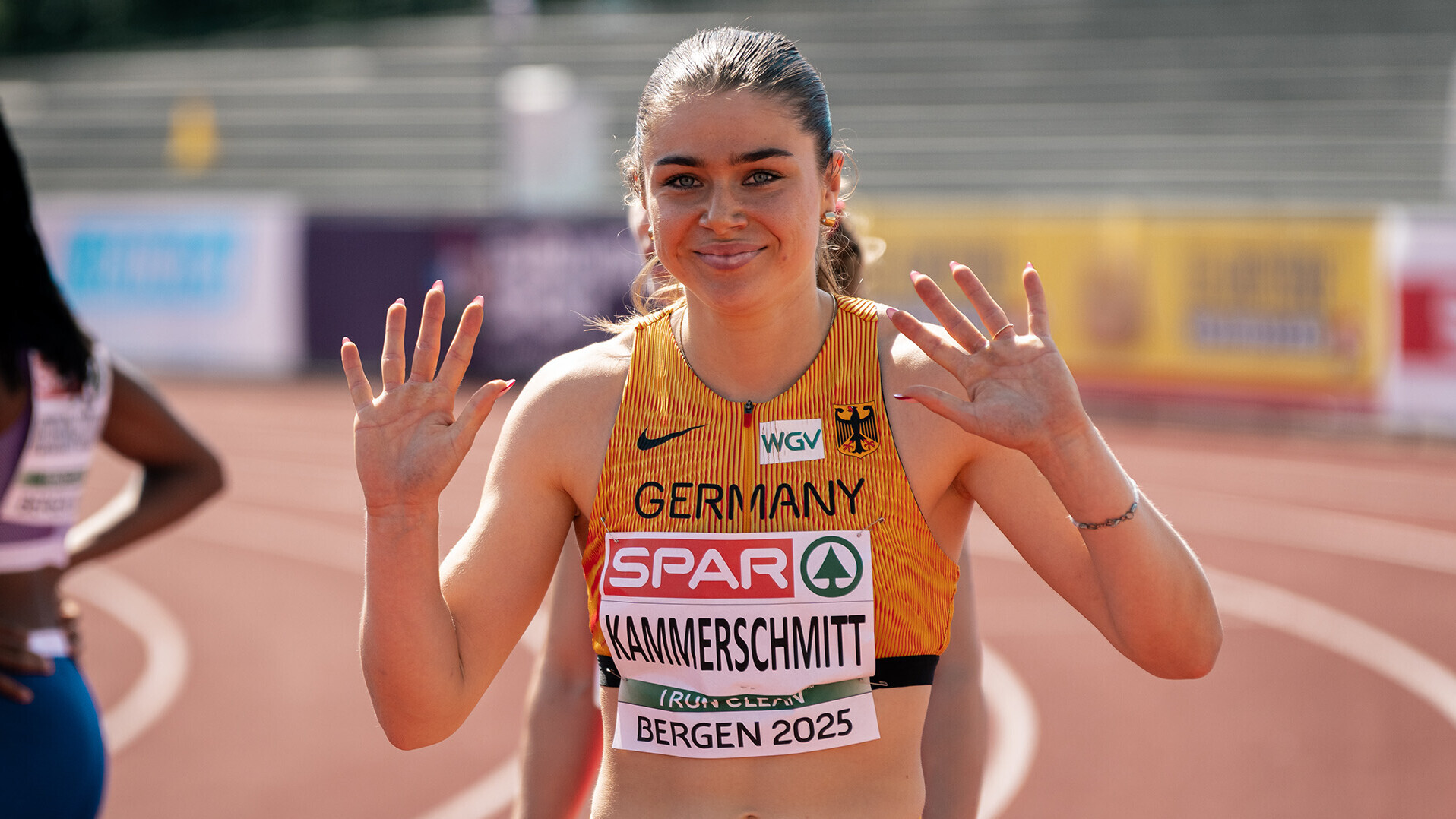 Sprinterin Sina Kammerschmitt winkt in die Kamera. 