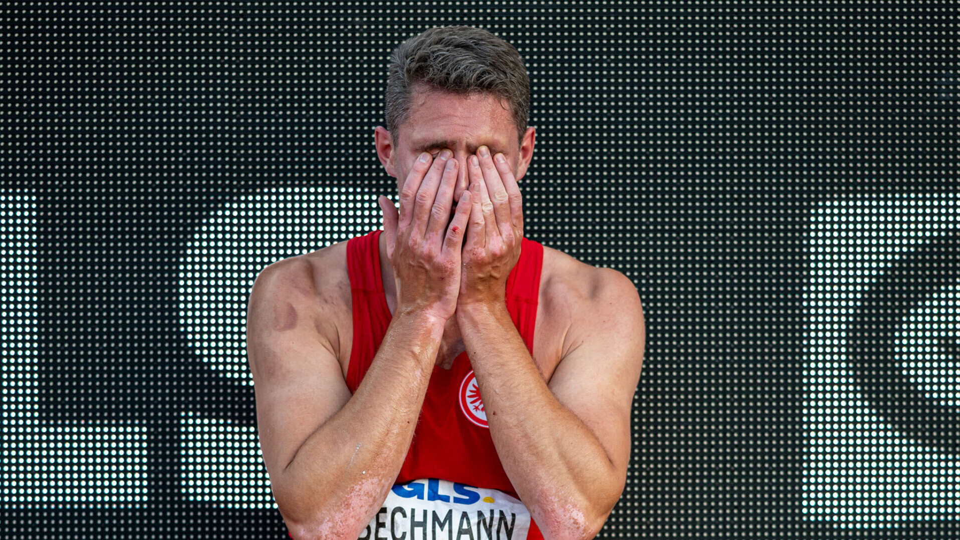 Andreas Bechmann sitzend, die Hände vors Gesicht geschlagen. 