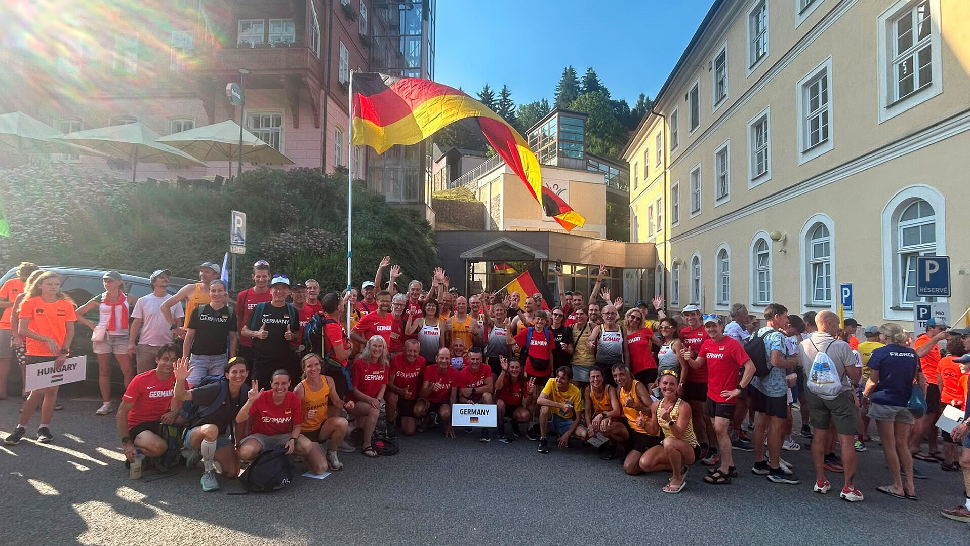 Eine Gruppe Personen in deutscher Nationalmannschaftskleidung hinter einer Deutschlandfahne