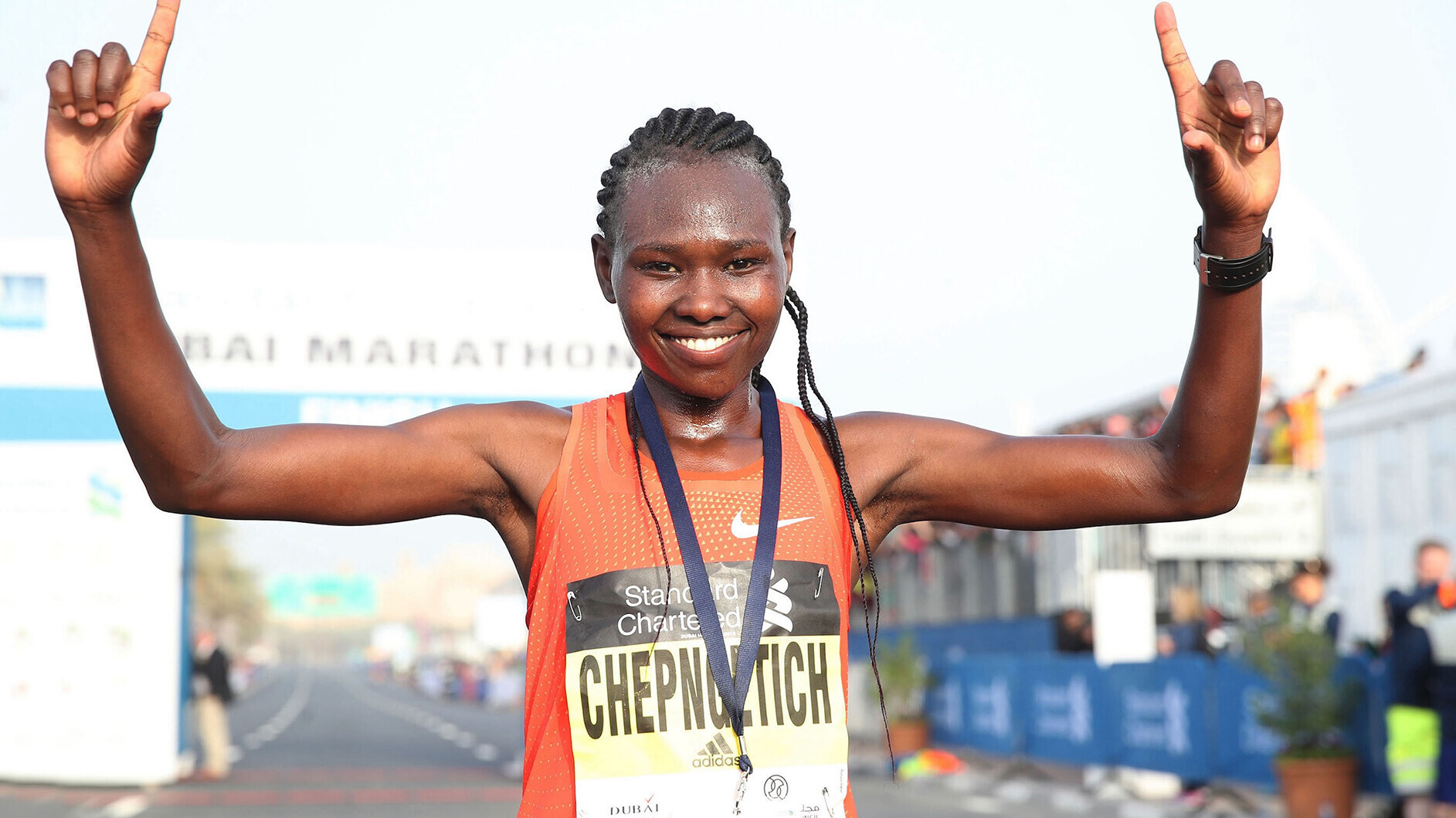 Ruth Chepngetich läuft mit erhobenen Händen bei einem Marathon durchs Ziel. 