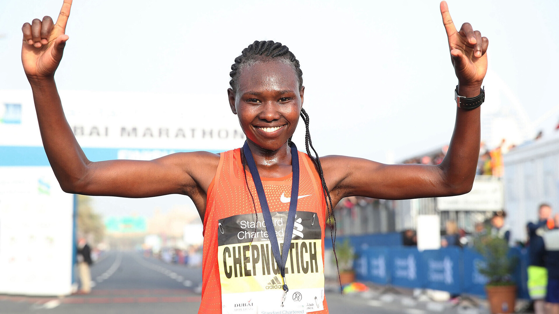 Ruth Chepngetich läuft mit erhobenen Händen bei einem Marathon durchs Ziel. 